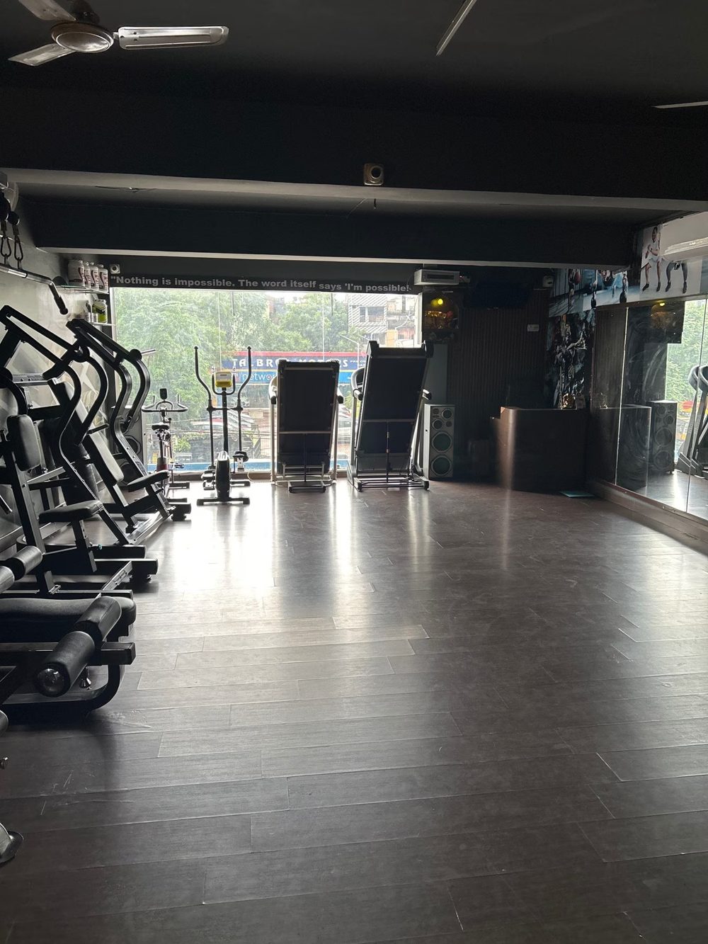 Treadmills and cross trainers in front of a large window