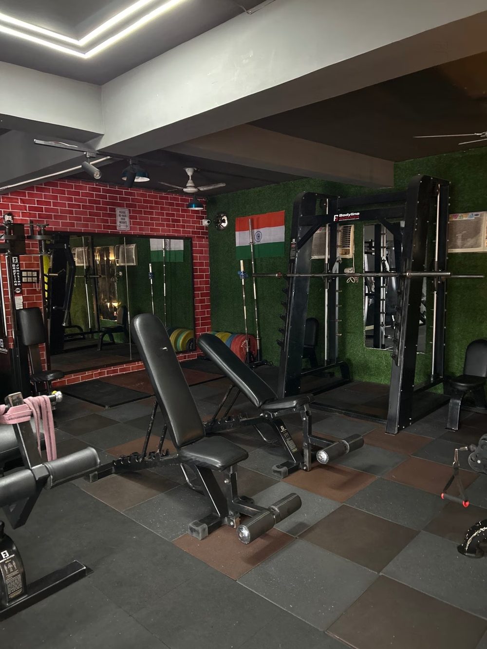 Benches and a smith machine on green turf